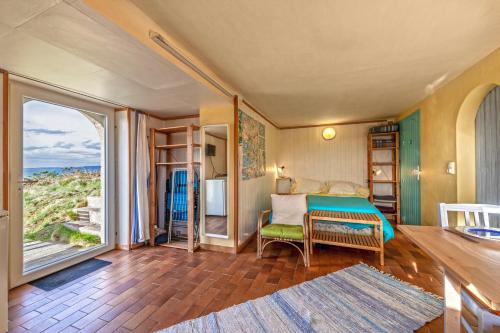 a bedroom with a bed and a large window at Studio vue sur mer in Plomodiern