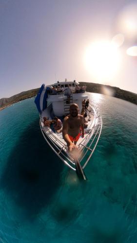 a man sitting on a boat in the water at MAYA in Paphos City
