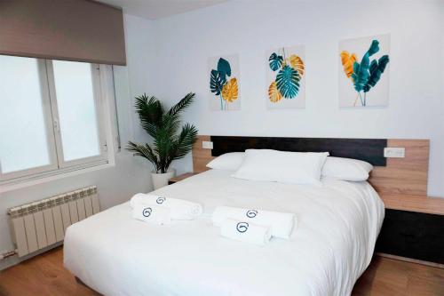 um quarto com uma grande cama branca e 3 toalhas em Sal Catedral Suite en pleno corazón de León em León