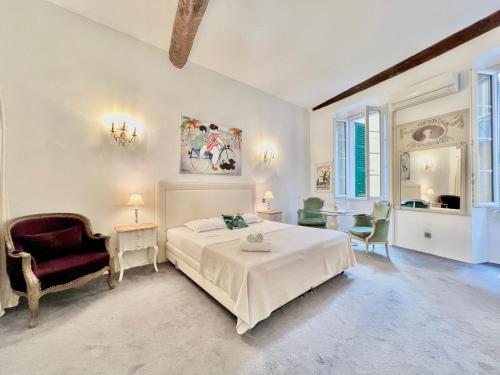 une chambre blanche avec un lit et une chaise dans l'établissement ApartHotel Riviera - Maison du Senat - Vieille Ville - Triplex 4 pièces à deux pas de la plage, à Nice