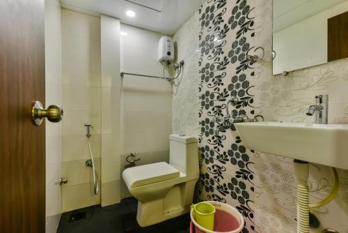 a bathroom with a toilet and a sink at Hotel Guestinn Residency in Mumbai
