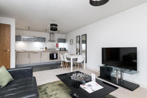 - un salon avec un canapé et une table dans l'établissement City Stay Apartments - Vizion, à Milton Keynes