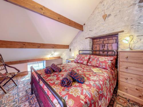 a bedroom with a bed and a stone wall at Yr Hen Efail in Abergorlech