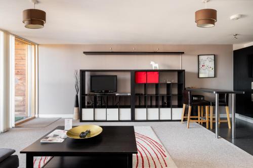 a living room with a table and a television at City Stay Apartments - Vizion in Milton Keynes