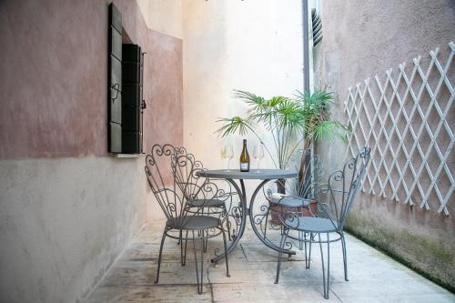 Ca' Latina - Cozy home in pieno centro storico في تريفيزو: طاولة وكراسي عليها زجاجة من النبيذ
