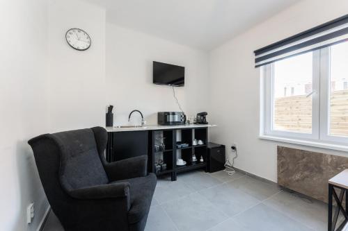 a living room with a chair and a television at Apartmány Praha-Modřany in Prague