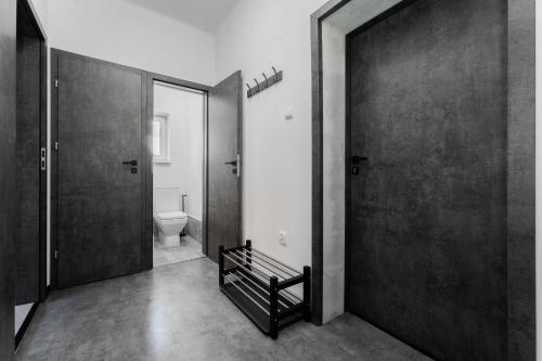 a black and white bathroom with a toilet and a door at Apartmány Praha-Modřany in Prague