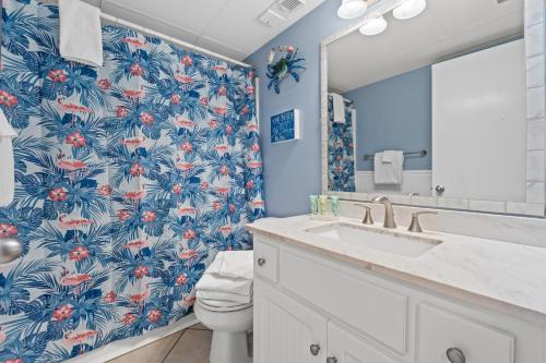 baño con papel pintado de flores azul y rojo en AquaVista Resort 805-W By Book That Condo en Panama City Beach