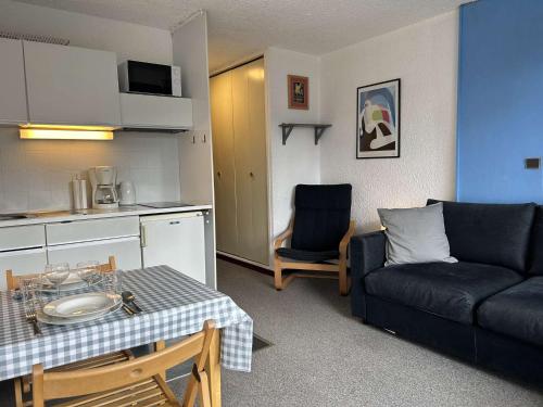 Il dispose d'une cuisine et d'un salon avec un canapé et une table. dans l'établissement Confortable studio 2 pers. à Montgenèvre, balcon ouest, bien équipé, parking, options WiFi et linge - FR-1-330D-22, à Montgenèvre