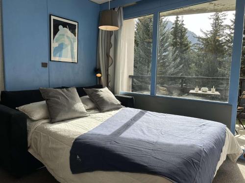 une chambre avec un grand lit avec une grande fenêtre dans l'établissement Confortable studio 2 pers. à Montgenèvre, balcon ouest, bien équipé, parking, options WiFi et linge - FR-1-330D-22, à Montgenèvre