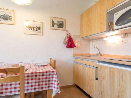 une petite cuisine avec une table et un évier dans l'établissement Charmant studio Montgenèvre, 3 pers, balcon sud, proche pistes - FR-1-330D-31, à Montgenèvre