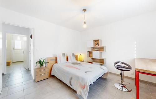 een witte slaapkamer met een bed en een bureau bij 2 Bedroom Amazing Home In Landvant in Landévant