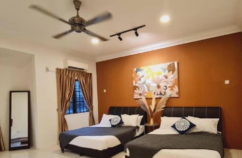 a bedroom with two beds and a ceiling fan at Pleasant Stay @ Sunway (16-20 pax ) 5 min to Lost World of Tambun in Tambun