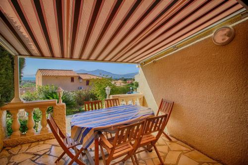 un patio avec une table et des chaises sur un balcon dans l'établissement Villa Terra Bella 2 PORTICCIO, à Porticcio