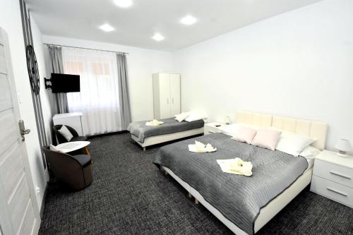 a hotel room with two beds and a chair at Villa Sovita in Łeba