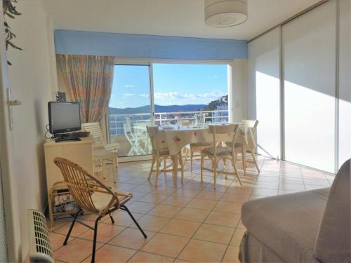 un salon avec une table et des chaises et un balcon dans l'établissement Appartement 2 pièces, terrasse, proche plage et centre, Le Lavandou - FR-1-251-345, au Lavandou