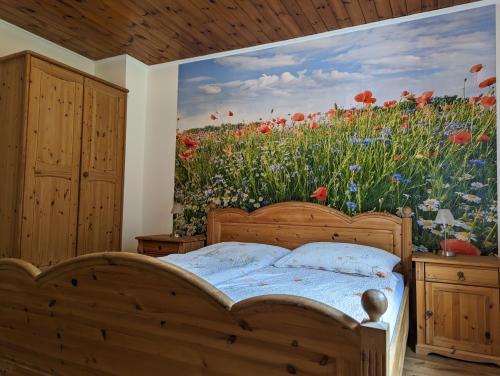una camera da letto con un murale di un campo di fiori di Frühstückspension Eibenstein 