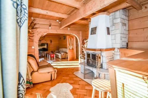 a living room with a fireplace in a log cabin at Domek u Horarów in Ciche