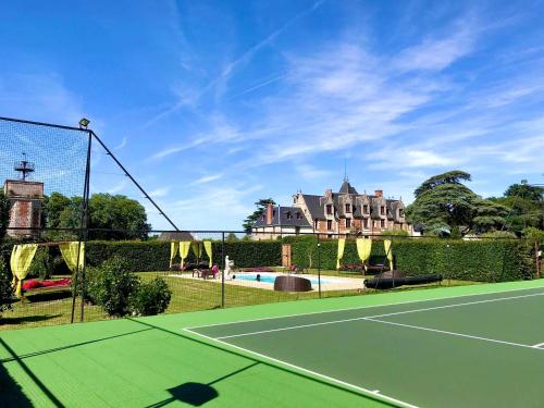 een tennisbaan met een huis op de achtergrond bij MEUBLE PANORAMIQUE 2 à 6 PERSONNES AU CHÂTEAU DE JALLANGES in Vernou-sur-Brenne