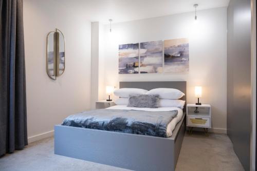 a bedroom with a bed with two night stands and two lamps at Newly Furnished Apt w/ Patios - Hampstead Heath in London
