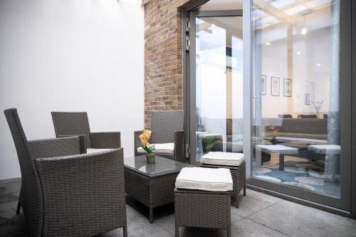 a patio with wicker chairs and a table at Newly Furnished Apt w/ Patios - Hampstead Heath in London