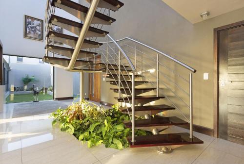 a spiral staircase in a house with plants at Baronetcy Kings Villa by Host Agents in Plattekloof