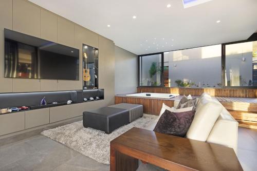 a living room with a couch and a tub at Baronetcy Kings Villa by Host Agents in Plattekloof