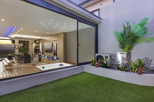 a living room with a large window and a bath tub at Baronetcy Kings Villa by Host Agents in Plattekloof