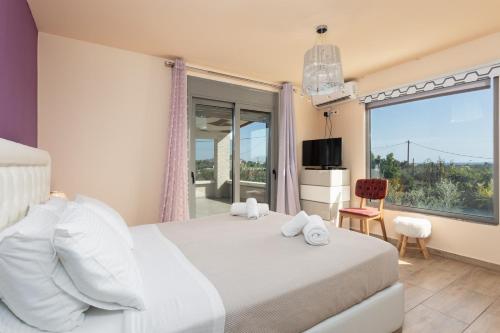 a bedroom with a bed and a large window at Villa Ammos in Afantou