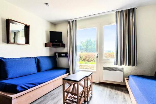 a living room with a blue couch and a window at Location Appartement Arzon (56640) 4 personnes in Arzon