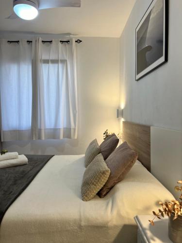 a bedroom with a bed with pillows and a window at Disfruta del Paraiso in Son Parc