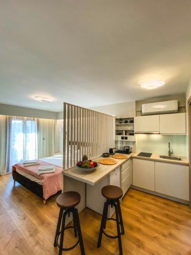 a kitchen with two stools and a counter with a table at Βενετία in Vathý