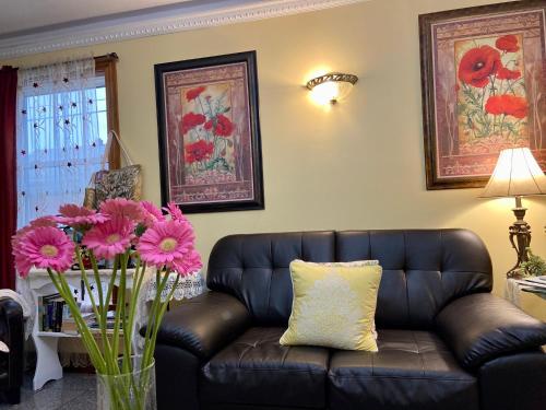 a living room with a couch and flowers in a vase at Inn on the Harbour in Charlottetown