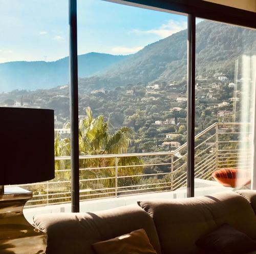 a living room with a couch and a large window at Villa Hirondelles 35 in Cavalaire-sur-Mer