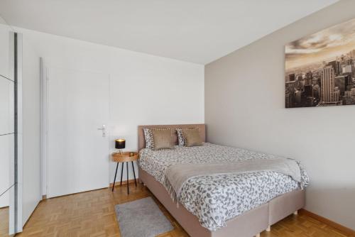 um quarto com uma cama e um quadro na parede em Athénée 36 Résidence by Homenhancement em Genebra