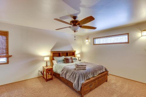 a bedroom with a bed and a ceiling fan at Wasilla Spruce Moose Cabin Lakefront and Hot Tub! in Wasilla