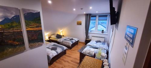 ein Hotelzimmer mit 2 Betten und einem Fenster in der Unterkunft Jurajskie Manowce in Niegowa