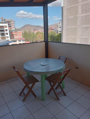 a green table and two chairs on a balcony at Posada de Mama in Cusco