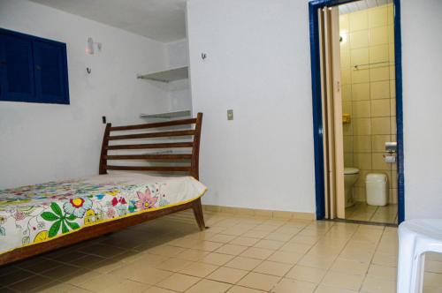 a bedroom with a bed and a bathroom with a toilet at Casa em Maracajaú in Maracajaú