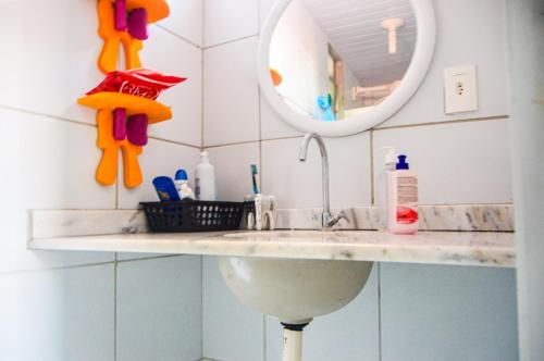 W łazience znajduje się umywalka i lustro. w obiekcie Casa em Maracajaú w mieście Maracajaú