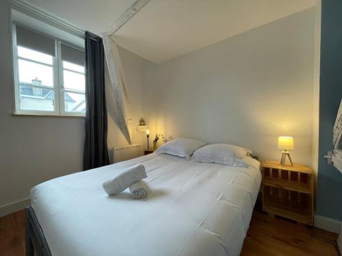 a large white bed in a room with a window at Le Cocon - Parking - Hyper Center in Chartres