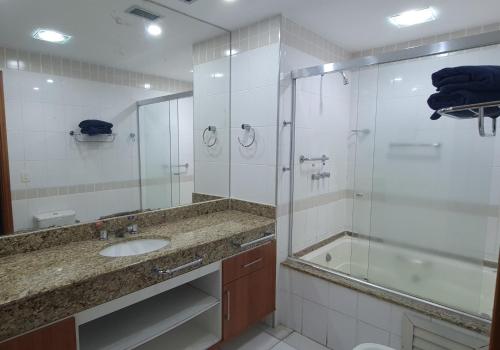 a bathroom with a shower and a sink and a tub at Cobertura Presidencial Tropical Hotel in Manaus