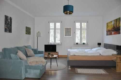 uma sala de estar com uma cama e um sofá em Villa Belino em Ruhla