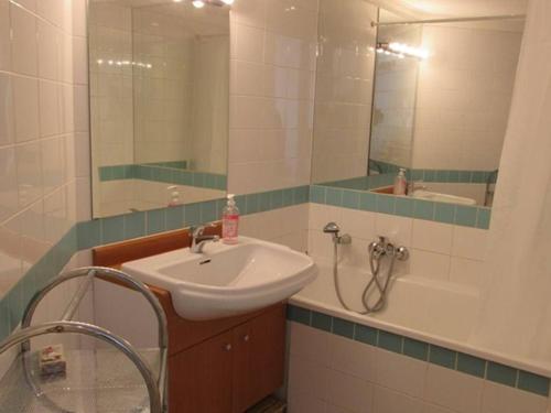 a bathroom with a sink and a tub and a mirror at Appartement calme au cœur de Cavalaire, climatisé avec terrasse, parking et toutes commodités - FR-1-100-233 in Cavalaire-sur-Mer