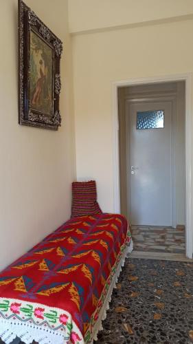 a bedroom with a bed with a colorful blanket on it at O'GERA Greek resort house in the mountains in Kókla