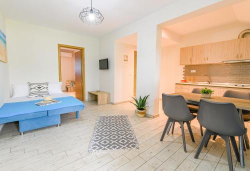 リメナリアにあるLa Verde Apartmentsのベッド、テーブル、椅子が備わる客室です。