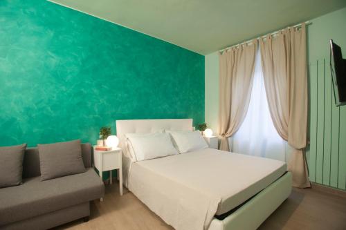 una camera con un letto bianco e un divano di La Casa Al Mare a Porto Santo Stefano