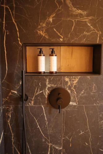 a bathroom with two soap dispensers on a marble wall at Apartamenty Morska 92 in Sasino