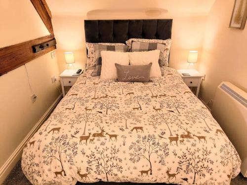 a bedroom with a bed with a bedspread with deer on it at Cosy Central Modern Apartment in Nantwich