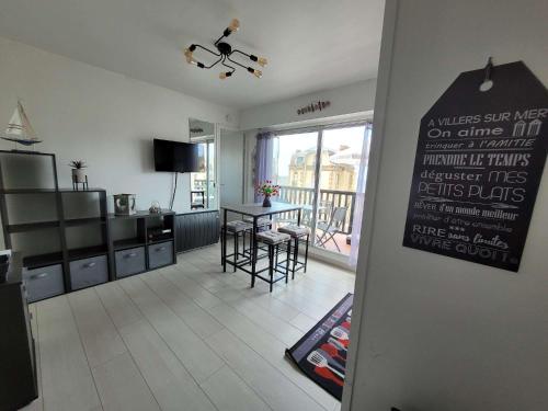 Una cocina y una sala de estar con mesa y sillas. en Manon's Studio, en Villers-sur-Mer